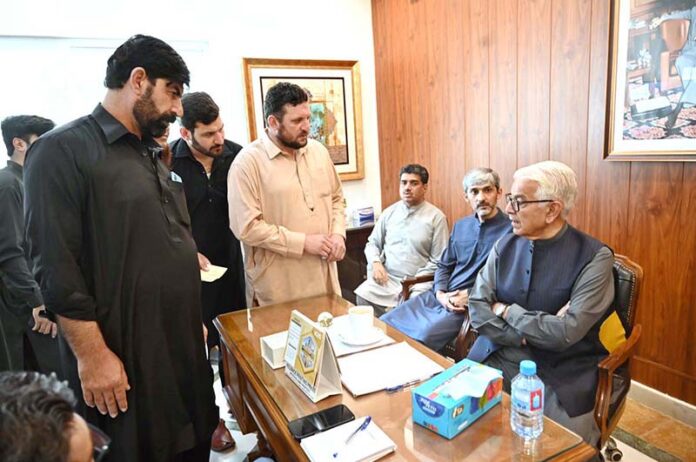 Defence Minister Khawaja Muhammad Asif listens to the problems of people during a public meeting at his residence