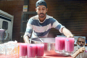 An elderly woman drinks a sweet beverage at Kharadar area to get relief from the scorching heat in the Provincial Capital