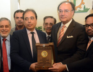 The Federal Finance Minister, Muhammad Aurangzeb receiving a souvenir shield from SVP Federation of Pakistan Chambers of Commerce and Industry Saqib Fayaz Magoon during a visit of FPCCI Head office