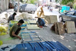 Workers busy in filling wood wool to make Aspen cooling pads for room air coolers at their workplace