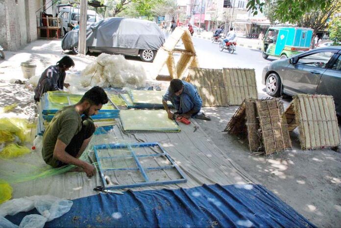 Workers busy in filling wood wool to make Aspen cooling pads for room air coolers at their workplace