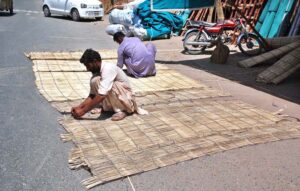Workers busy in filling wood wool to make Aspen cooling pads for room air coolers at their workplace
