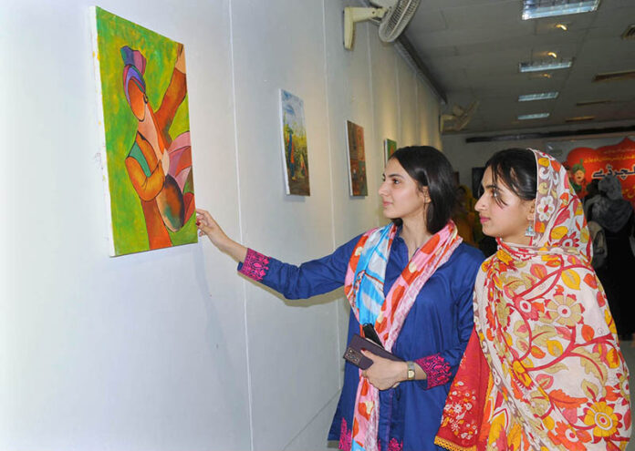 Female art enthusiasts admire the artwork on display during the Punjab Culture Day event, organized by the Information and Culture Department at Multan Arts Council