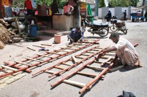 Workers busy in filling wood wool to make Aspen cooling pads for room air coolers at their workplace