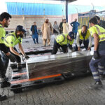 Staff at the airport are placing the body of a Pakistani who died in the Libya boat tragedy at the cargo terminal
