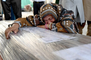 Staff at the airport are placing the body of a Pakistani who died in the Libya boat tragedy at the cargo terminal