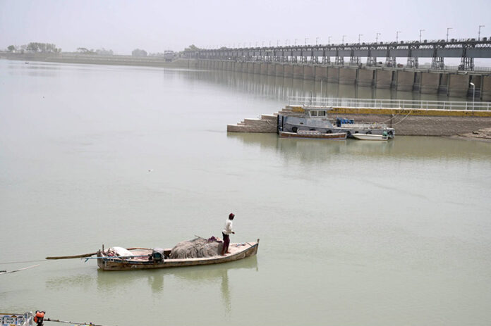A fisherman fishing on his boat at Indus river
