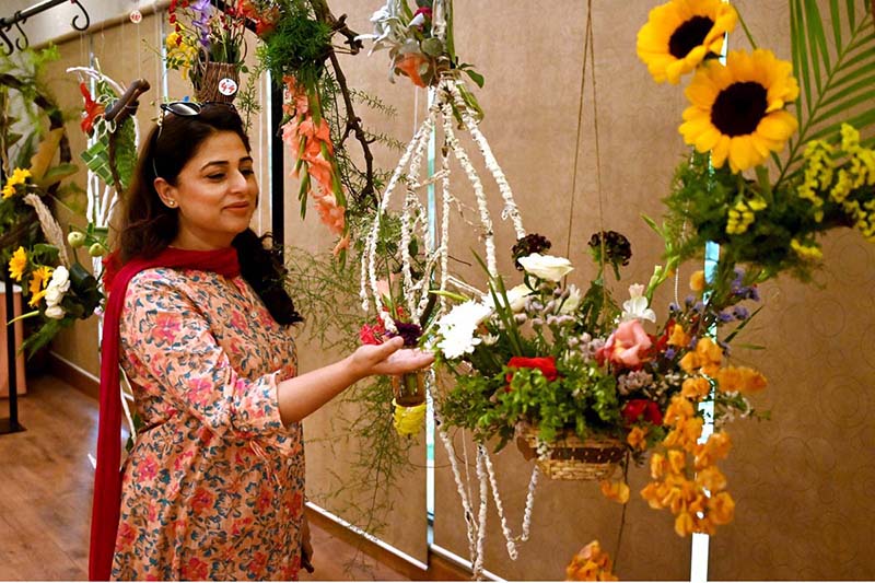 A nature lover admires the beautiful floral displays at the 76th Annual Flower Show 2025, organized by Attock Oil Group of Companies at Morgah Club
