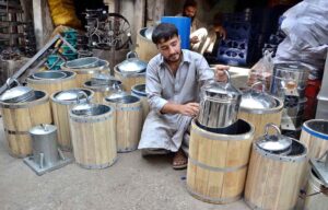 A vendor prepares manual ice cream boxes for homemade ice cream as temperatures rise in the city.