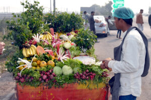 Vendor busy in selling fresh organic vegetables salad on his cart in the city because people think organic food is safer, healthier, and tastier around the world.