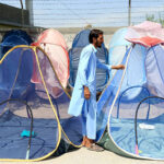 A vendor sells mosquito nets to keep locals safe and protect them from dengue bites at a roadside setup near Faqirabad area