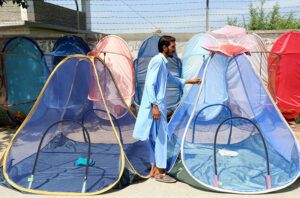 A vendor sells mosquito nets to keep locals safe and protect them from dengue bites at a roadside setup near Faqirabad area