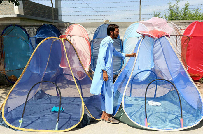 A vendor sells mosquito nets to keep locals safe and protect them from dengue bites at a roadside setup near Faqirabad area