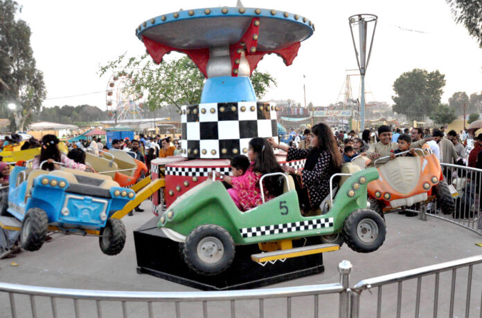 Children enjoying the mechanical swings during 3rd day of Eid-ul-Fitr celebrations at Funland