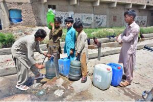 Children filling water containers at a hand pump in Hala Naka Area.