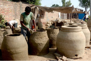 A potter shapes a traditional clay oven at his workplace in outskirts area of the provincial capital
