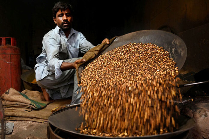 A vendor is busy roasting grams at his roadside setup in the Provincial Capital