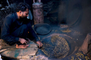A vendor is busy roasting grams at his roadside setup in the Provincial Capital