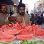 A street vendor sells sliced ​​watermelon to customers despite failure to comply with health and hygiene standards