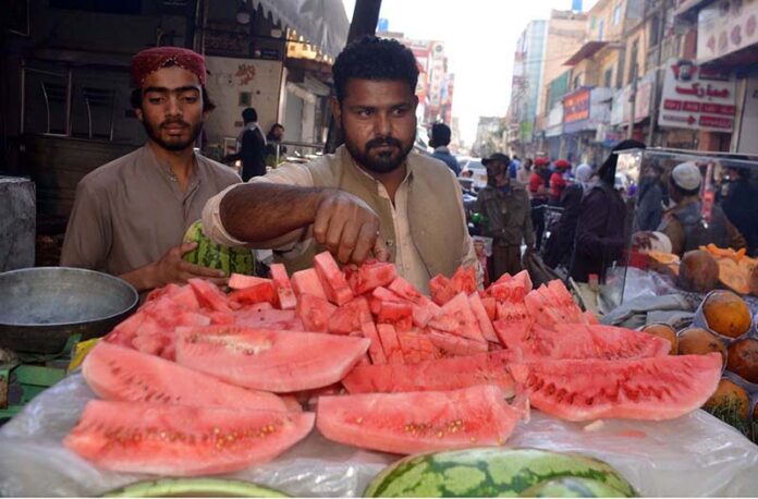 A street vendor sells sliced ​​watermelon to customers despite failure to comply with health and hygiene standards