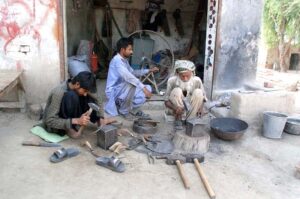 An artisan preparing items which would be used for cutting of standing wheat crops as wheat crop cutting season will fall soon.
