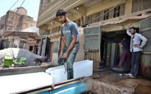 A labour loading the ice block to Suzuki pickup at Ice Factory to deliver in different areas as demand increased due to hot weather in the city.
