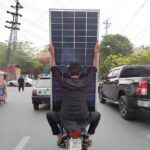 Motorcyclists carry solar panels on Davis Road under Punjab Chief Minister’s solar scheme, aimed at reducing electricity bills for low-consumption households
