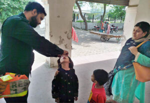 Rescue 1122 personnel administer polio drops to children at the railway station under the Polio-Free Pakistan campaign