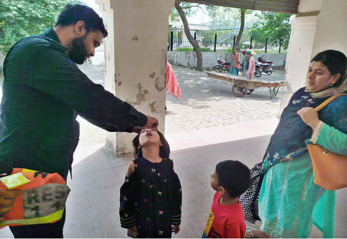 Rescue 1122 personnel administer polio drops to children at the railway station under the Polio-Free Pakistan campaign