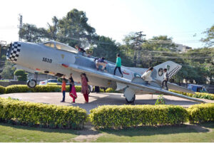 Children enjoy their holidays and taking pictures with a Pakistan Air Force plane displayed as a monument at China Chowk