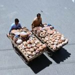 Street vendors push handcarts filled with handmade clay pots, striving to earn a daily livelihood