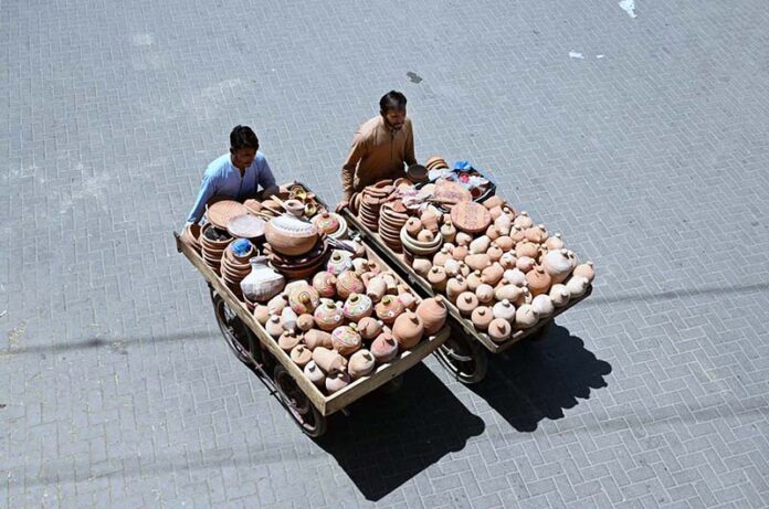 Street vendors push handcarts filled with handmade clay pots, striving to earn a daily livelihood