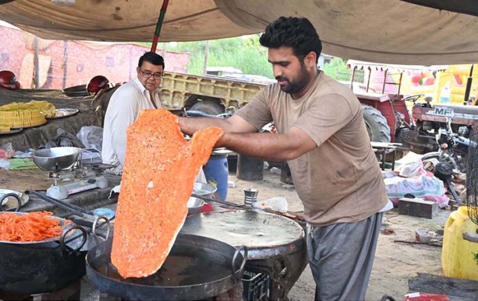 A vendor prepares traditional food Item kutlama to attract customers at his roadside setup