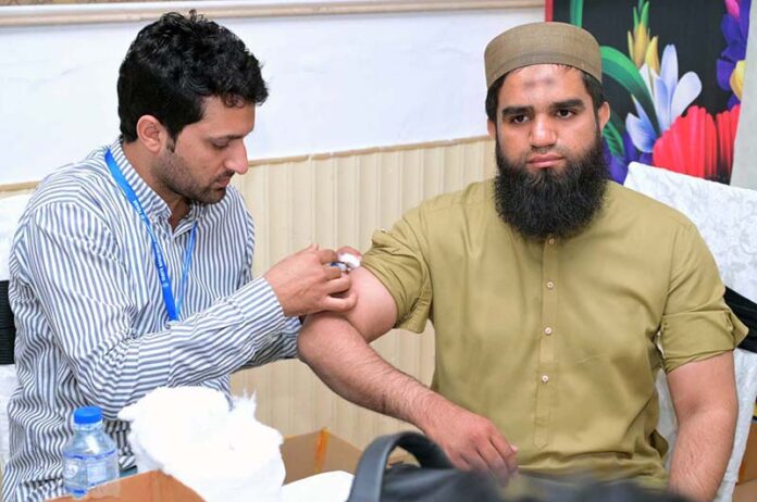 Health Department staff at the Hajj Camp of the Ministry of Religious Affairs, Government of Pakistan, administers vaccinations to Hajj pilgrims to protect them against diseases