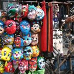 A street vendor displays a variety of plastic cartoon character masks to attract children while shuttling in the provincial capital
