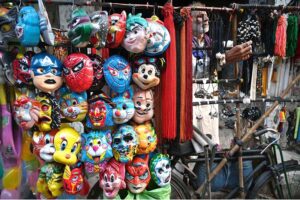 A street vendor displays a variety of plastic cartoon character masks to attract children while shuttling in the provincial capital