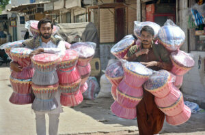 Vendors selling (Murha) traditional stool while shuttling on the road at Qayyumabad.