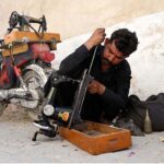 A mechanic busy in repairing a sewing machine in a street near Khaliq Colony