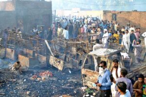 Firefighters are trying to extinguishing a blaze triggered by a cylinder explosion in Liaquat Colony