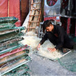 A worker busy in preparing (khas) to be used in air cooler at his workplace in the Provincial Capital