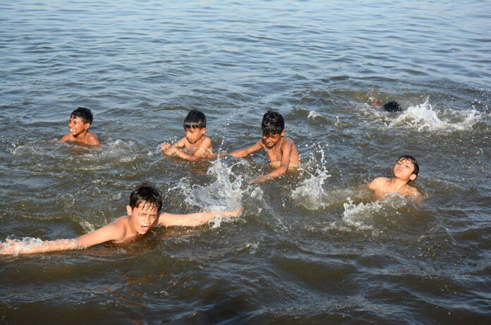 Children enjoy swimming in the Arabian Sea (local jetty) to get relief from the hot weather