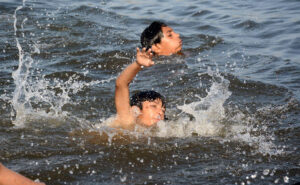 Children enjoy swimming in the Arabian Sea (local jetty) to get relief from the hot weather