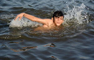 Children enjoy swimming in the Arabian Sea (local jetty) to get relief from the hot weather