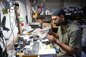 A mechanic repairs digital watches at Hall Road market.