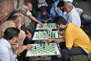 Locals enjoy a game of chess on the roadside near Lakshami Chowk during the pleasant evening in the provincial capital