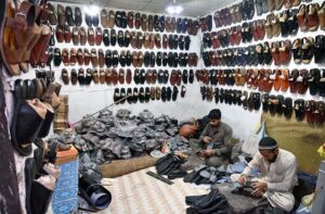 Cobblers preparing the traditional shoes (Peshawari Chappal) at their workplace.