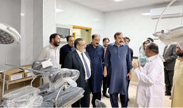 Federal Minister for Parliamentary Affairs, Dr. Tariq Fazal Chaudhary being briefed by administration at Bari Imam Community Health Centre in federal capital