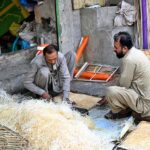 Workers use wood wool to make Aspen cooling pads for traditional air room coolers at his workplace in the provincial capital