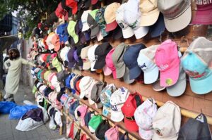 A roadside vendor displays a colorful collection of caps to attract passersby as the summer season approaches in the provincial capital