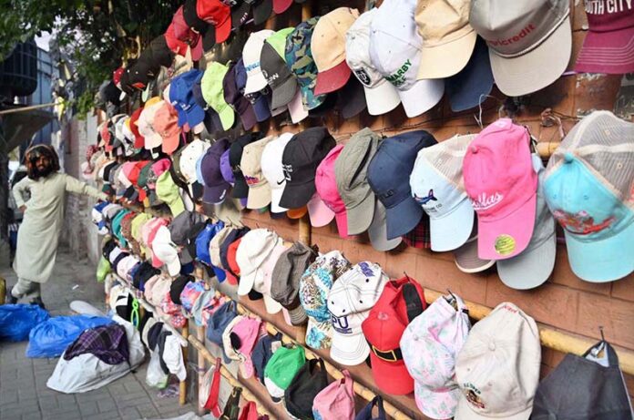 A roadside vendor displays a colorful collection of caps to attract passersby as the summer season approaches in the provincial capital